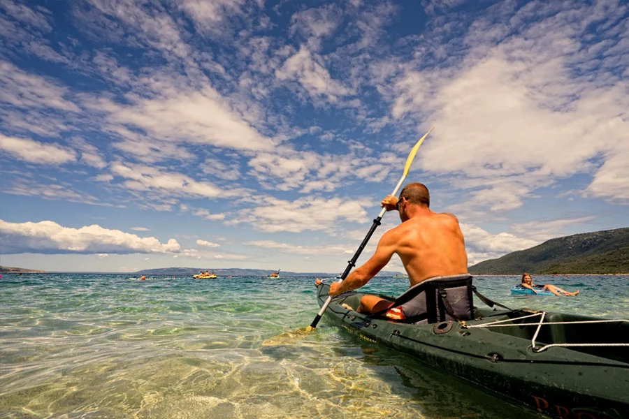 Kayaker on crystal clear sea of Cres Island