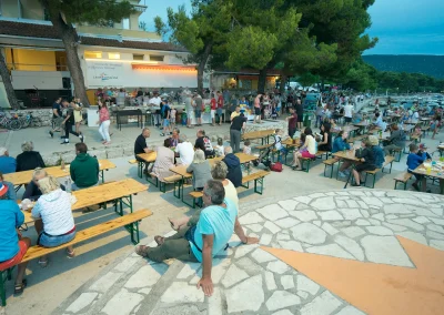Gosti uživaju na Gril fešti ispred marketa u kampu Kovačine