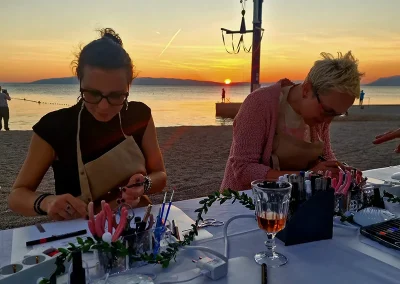 Sudionice izrađuju nakit na Sip & Create radionici u kampu Kovačine uz zalazak sunca